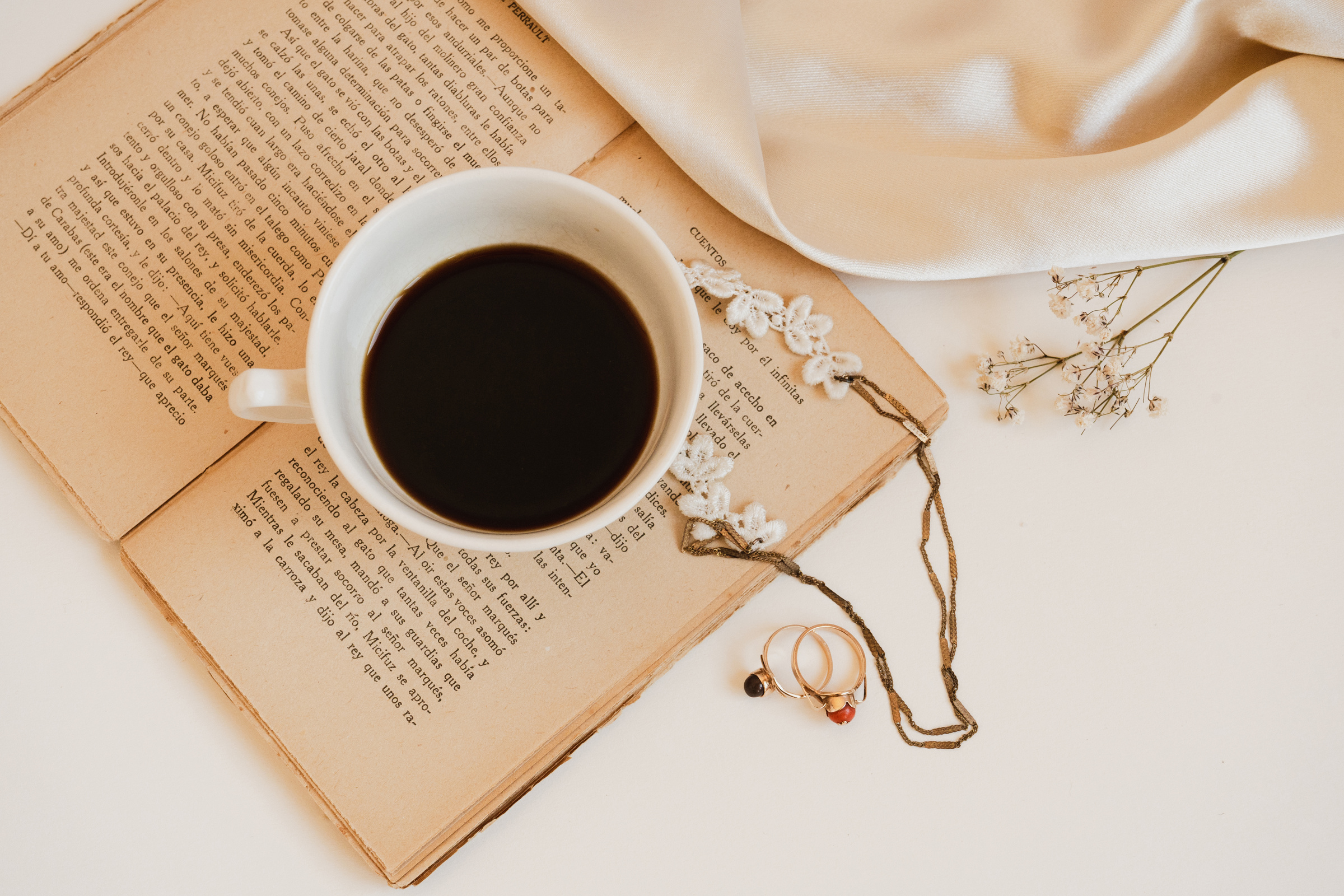 Pearl Necklace and Earrings with Cup of Coffee on Book